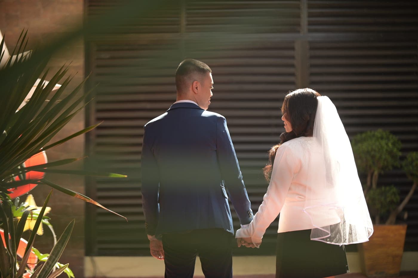 Josh and Deborah in wedding attire, hand in hand